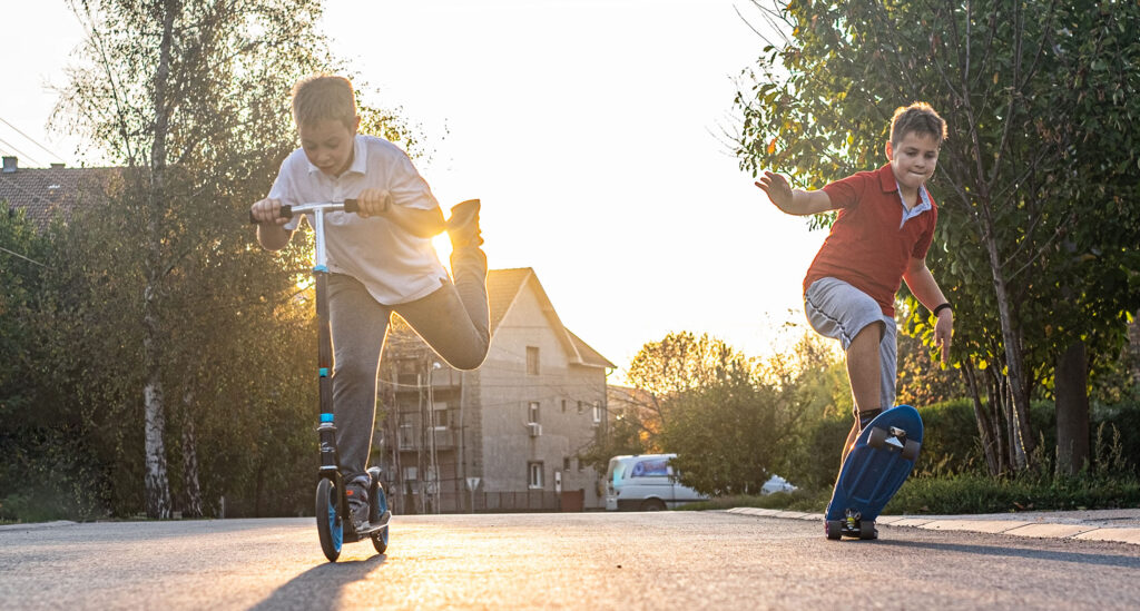 April Housing News & Events Two Boys Skateboarding and Scootering in the City through Affordable Apartments