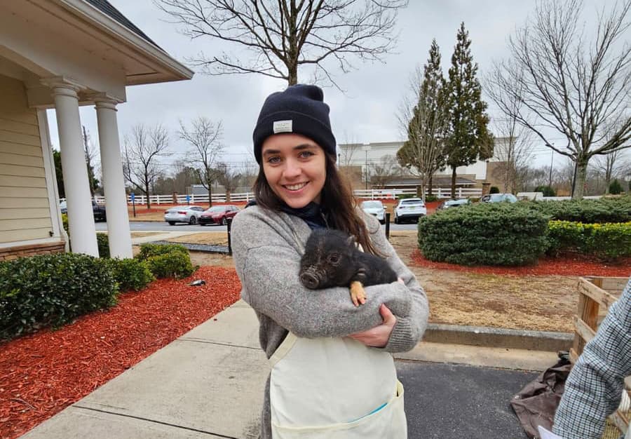 Victoria Scotti with piglet at farm animal petting zoo.